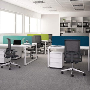 kolorowe biurowe z dużymi oknami obok których stoją biurka